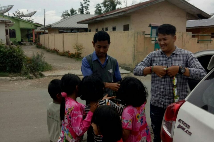 Amsalta Sinuhaji saat berbagi cemilan dengan anak-anak