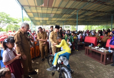 Bupati Batu Bara Zahir saat memberikan hadiah kepada salah satu pelajar (foto: KominfoBB)
