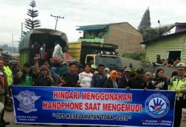 Sat Lantas Polres Tanah Karo berfoto usai melakukan sosialisasi dengan pengendara.